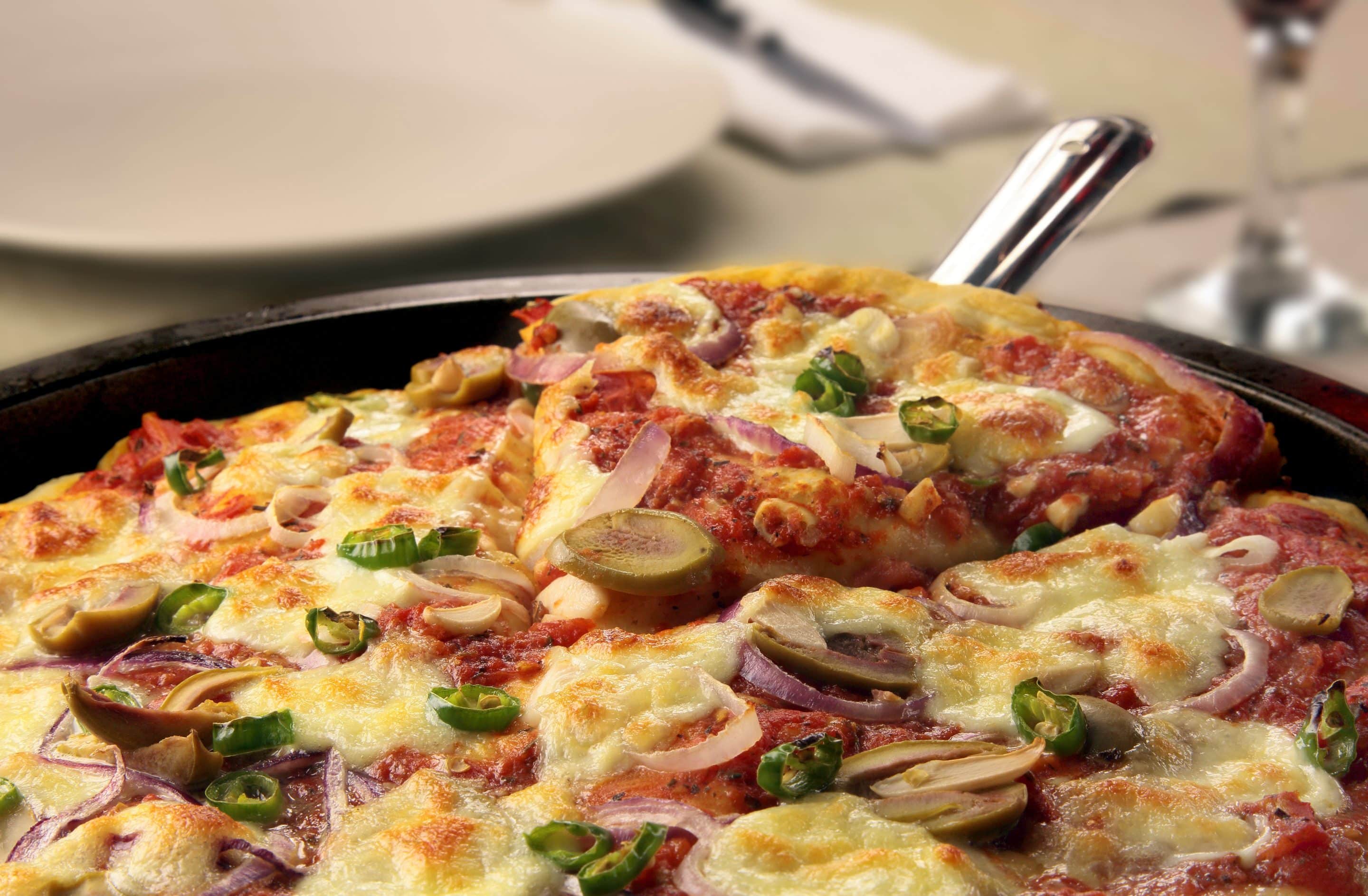 Pizza with mozzarella, red onion, olives and chilis