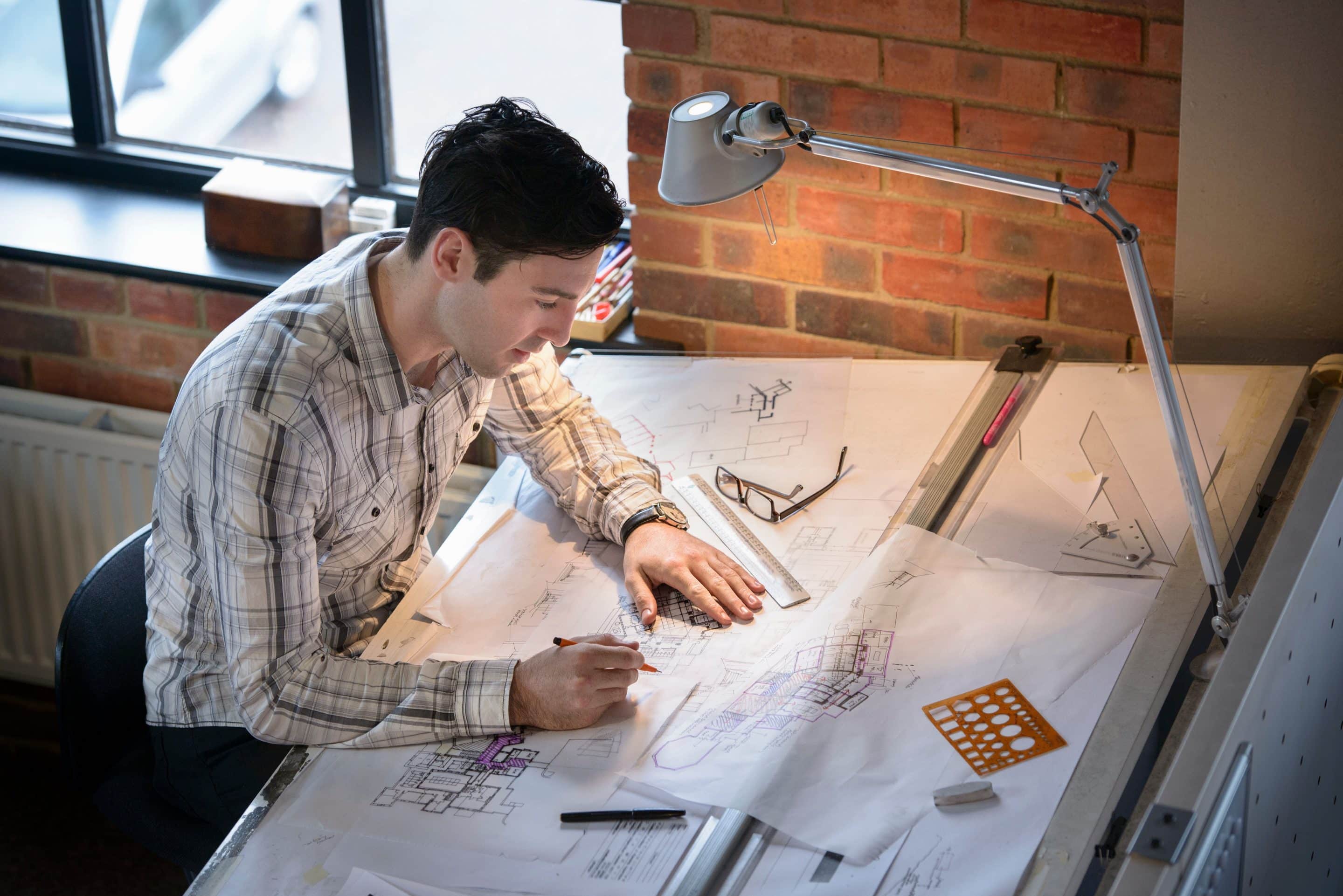 Architect drawing plans at drawing board