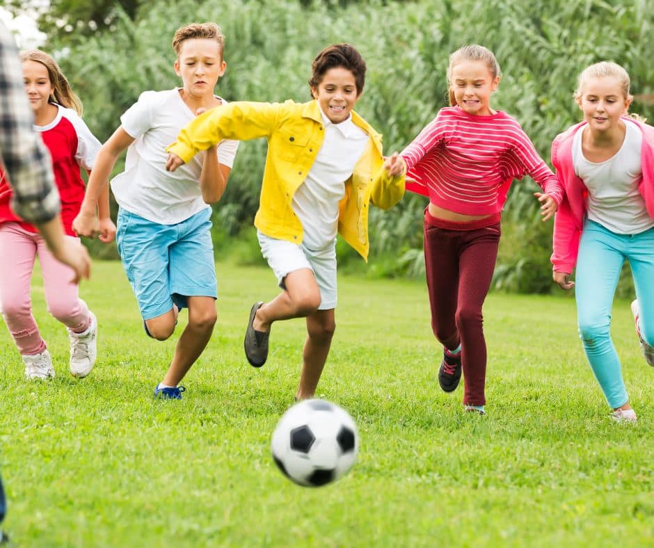 school holidays kids playing football in a park, maybe in February half term in Solihull