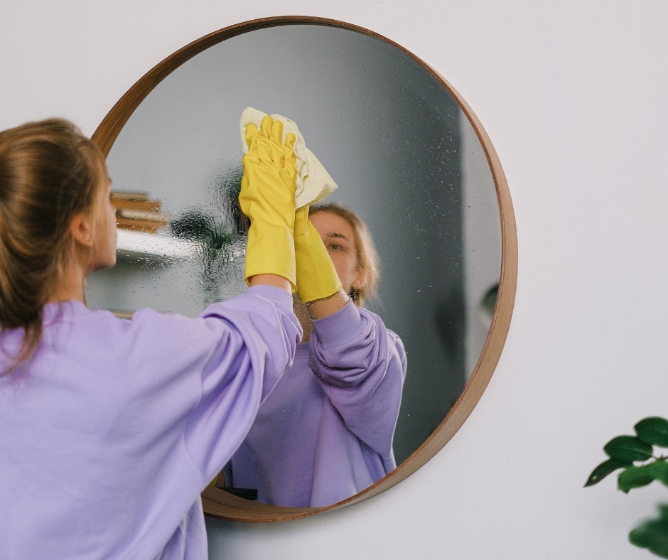 Spring clean photo of woman cleaning a mirror