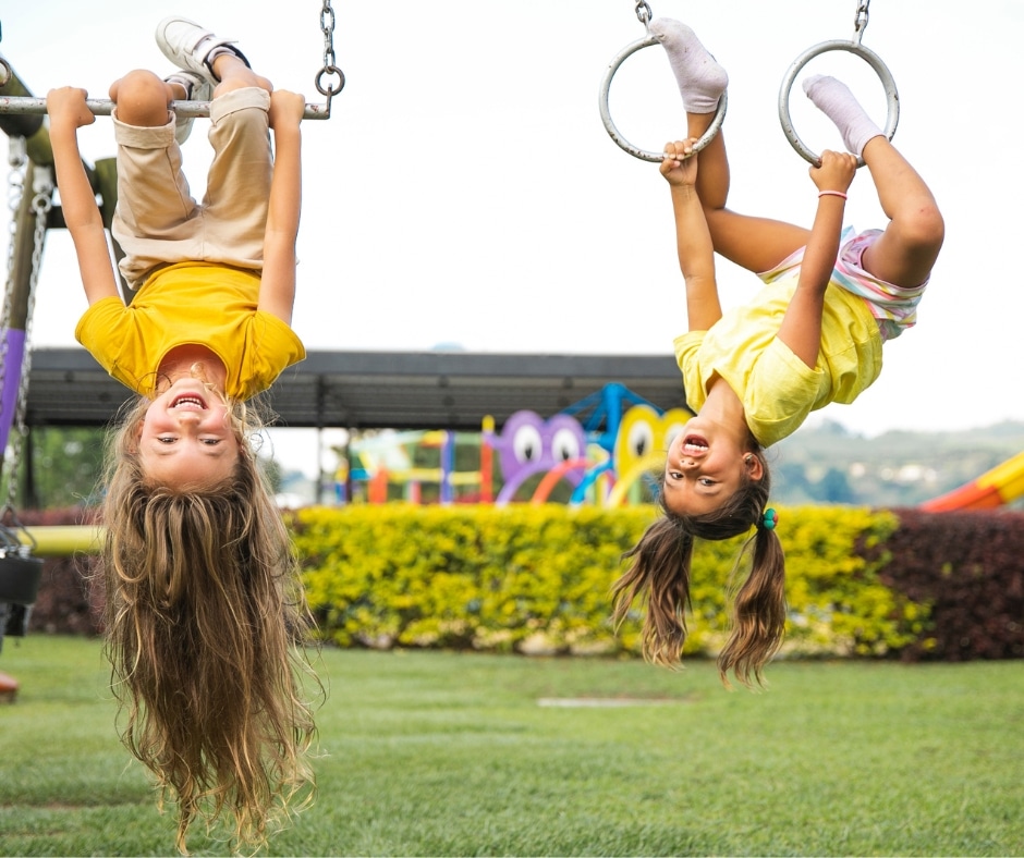 kids hanging upside down in a playground