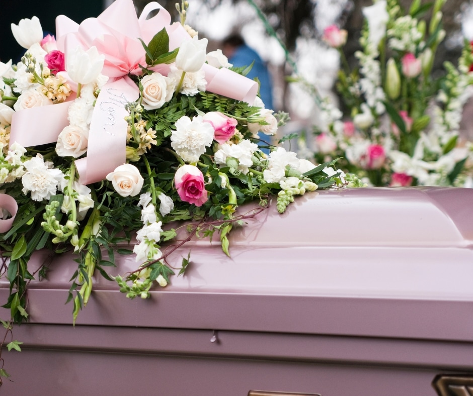 Photo of coffin with funeral flowers on top